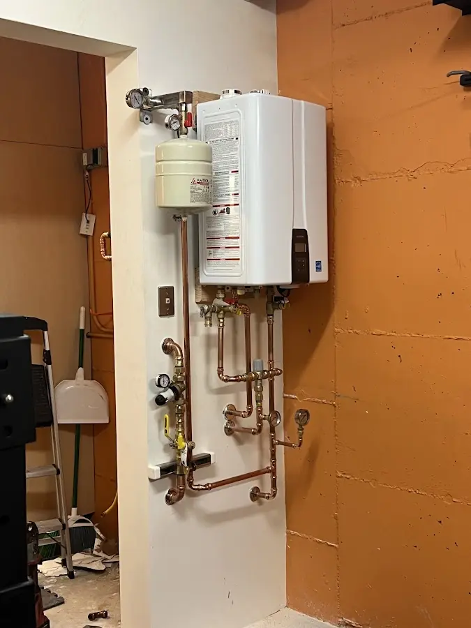 Plumbing technician inspecting water heater connections in Scott AFB